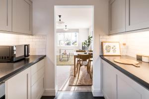 a kitchen with white cabinets and a kitchen with a table at No. 5 The Court-with FREE parking in Windermere