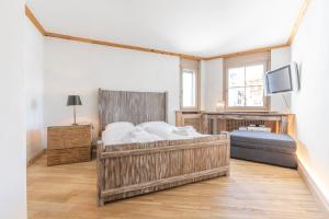 a bedroom with a large bed and a tv at St Moritz 3 Suite vista lago in St. Moritz