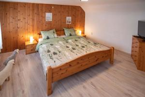 a bedroom with a large bed with a wooden wall at Ferienhaus Nepomuk in Lauterecken
