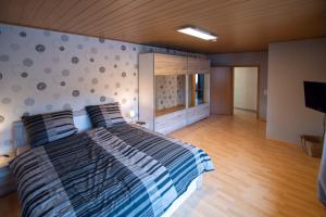 a bedroom with a large bed and a wall at Ferienhaus Nepomuk in Lauterecken