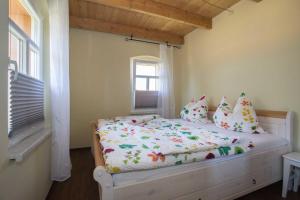 ein Schlafzimmer mit einem weißen Bett mit Kissen und einem Fenster in der Unterkunft Ferienhof Olbasee in Kleinsaubernitz