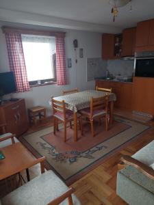 un soggiorno con tavolo e sedie e una cucina di Villa Sofija a Kopaonik