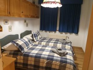 a bedroom with a bed with a blue and white blanket at Crans Cozy House in Crans-Montana