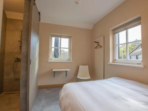 a bedroom with a bed and a sink and two windows at Jager en Hooijmijt xl in Gouwelaar