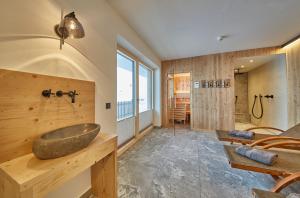 ein Badezimmer mit einem Steinwaschbecken an einer Holzwand in der Unterkunft AlmGlück Chalet auf 1740m in Saalbach-Hinterglemm