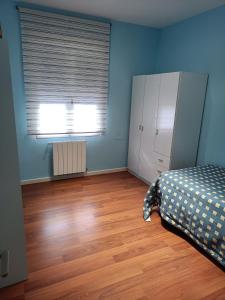 1 dormitorio con 1 cama y suelo de madera en Habitación privada en casa particular, en Albacete