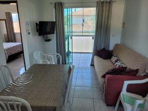 - un salon avec un canapé et une table dans l'établissement Aptos do Angelo, à Pinheira