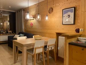 a dining room with a wooden table and chairs at Appartement cosy au pied des pistes in La Clusaz