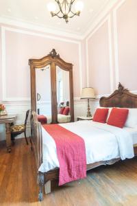 una camera da letto con un letto con cuscini rossi e uno specchio di Casa Turin a Città del Messico
