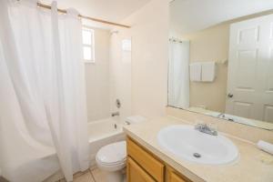 een badkamer met een wastafel, een toilet en een spiegel bij Royal Palm Bay 3 Bedroom Condo Resort Pool 10 Min Disney in Kissimmee +13 foto's