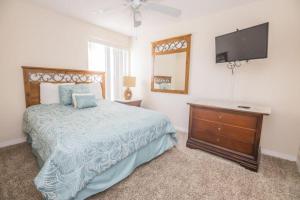 een slaapkamer met een bed en een flatscreen-tv bij Royal Palm Bay 3 Bedroom Condo Resort Pool 10 Min Disney in Kissimmee