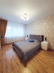 a bedroom with a large bed and a window at Dainai 1-Bedroom apartament. in Šiauliai