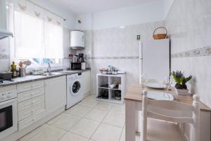 a white kitchen with a sink and a dishwasher at Sol&mar in Ponta do Sol