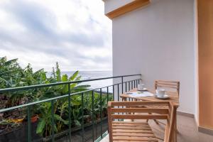 balcón con mesa y vistas al océano en Sol&mar, en Ponta do Sol
