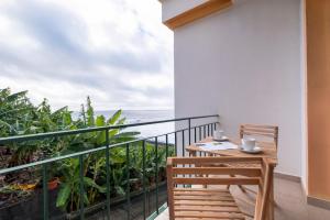a balcony with a table and a view of the ocean at Sol&mar in Ponta do Sol