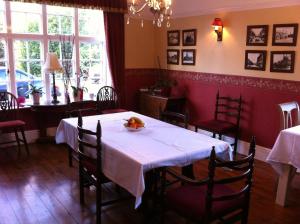 uma sala de jantar com uma mesa branca e cadeiras em Elloe Lodge em Holbeach