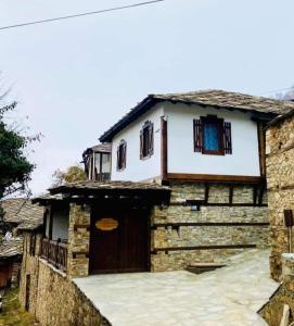 une maison avec une porte en bois devant elle dans l'établissement Къща за гости Близнаците, à Leshten