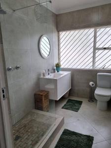 a bathroom with a shower and a sink and a toilet at One on Old Main, Unit 5 in Hillcrest