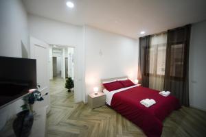 1 dormitorio con 1 cama roja y 2 toallas en Salifornia casa vacanze en Salerno