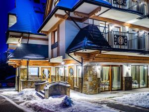 a house with a fireplace in the snow at Villa Taternik by Golden Apartments in Zakopane