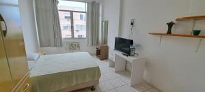 Dieses weiße Zimmer verfügt über ein Bett und einen TV. in der Unterkunft Amplo e excelente Apartamento Cod.1001 in Rio de Janeiro