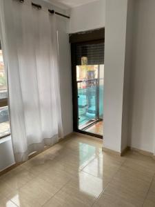 Habitación vacía con ventana y cortina blanca en Apartamentos Wei en Grao de Castellón