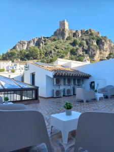 a patio with tables and chairs and a house at ALOJAMIENTO ÁGUILAS HOME zhr in Zahara de la Sierra