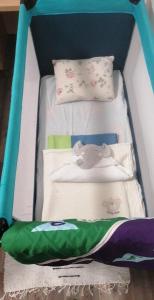 a baby crib with a bed with blankets and pillows at Eisenerzer Apartmenthaus in Eisenerz