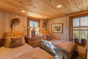1 Schlafzimmer mit 2 Betten und Holzdecke in der Unterkunft Beech Haven in Beech Mountain