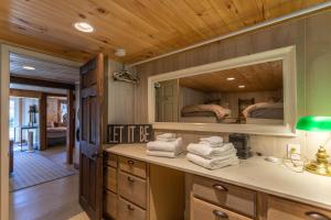 ein Badezimmer mit einem Waschbecken und einem Spiegel mit 2 Betten in der Unterkunft Beech Haven in Beech Mountain