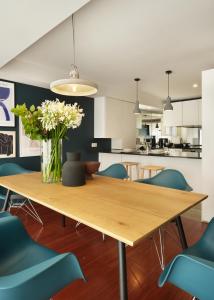 a dining room with a wooden table and blue chairs at Nº150 Apartment Triplex with Suites and Terrace in Braga