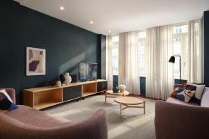 a living room with two chairs and a tv at Nº150 Apartment Triplex with Suites and Terrace in Braga