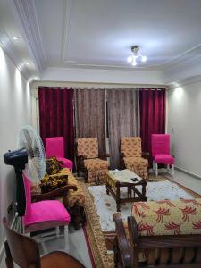 una sala de espera con sillas rosas y un ventilador en Lojii, en El Cairo