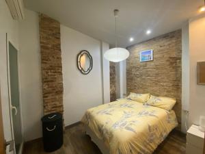バレンシアにあるYour Valencia Homeのベッドとレンガの壁がある寝室