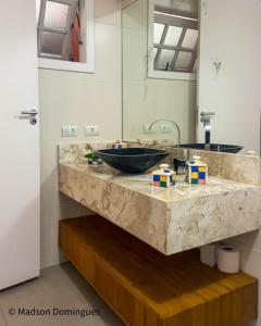 a bathroom counter with a sink and a mirror at CuatroCinco e Mundo BT - Casa de Hospedagem de Pessoas e Pets in São Sebastião