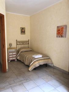 um quarto com uma cama e uma mesa de cabeceira num quarto em B&b Candido Vacanze em Modica