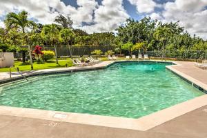 uma grande piscina com cadeiras e árvores em Pristine Lihue Condo with Balcony Walk to Beach! em Lihue