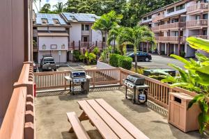 a balcony with a picnic bench and a grill at Pristine Lihue Condo with Balcony Walk to Beach! in Lihue