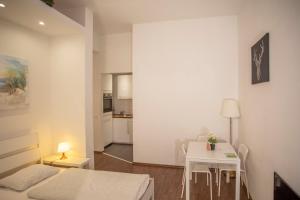 Habitación con cama, mesa y cocina. en Innsbruck City Center Studio I 24h self-check-in, en Innsbruck