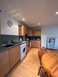 een keuken met houten kasten en een tafel met een wastafel bij Nevis Croft Apartment 2 in Fort William