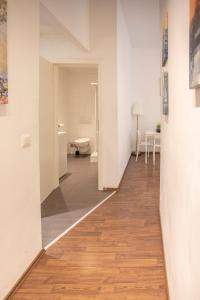 un pasillo con paredes blancas y suelo de madera en Innsbruck City Center Studio I 24h self-check-in, en Innsbruck