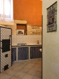 uma cozinha com um lavatório e piso em azulejo em B&b Candido Vacanze em Modica