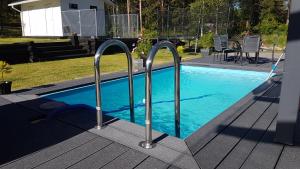 una piscina con due corrimano metallici in un cortile di VillaSki a Rovaniemi