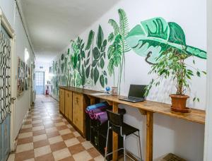 una camera con scrivania, computer portatile e piante sul muro di T5 Social a Bucarest