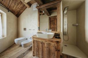 uma casa de banho com um lavatório, um WC e um espelho. em Luxury Cortina em Cortina dʼAmpezzo