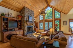 a living room with couches and a stone fireplace at Heart Rock Lodge in Sugar Mountain
