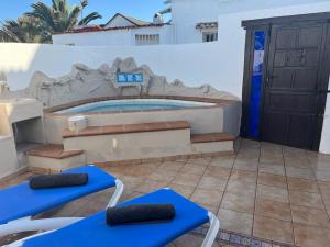 a swimming pool with blue tables and chairs in front of a building at Casa Sol y Luna in Costa Calma