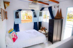 1 dormitorio con 1 cama, vestidor y ventanas en Casa remedios la bella, en Santa Marta