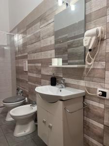 ein Badezimmer mit einem Waschbecken, einem WC und einem Spiegel in der Unterkunft B&B Appia Antica in Massafra