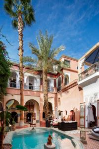 een groot huis met palmbomen en een zwembad bij Indian Palace in Marrakesh